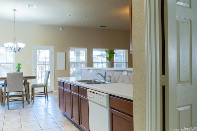 kitchen with decorative light fixtures, dishwasher, sink, a chandelier, and light tile patterned floors