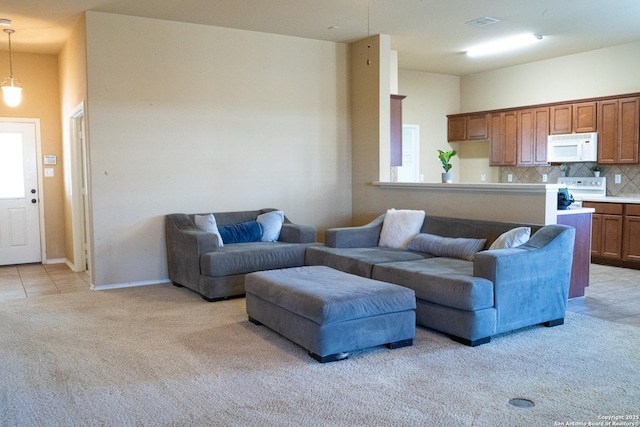 living room with a towering ceiling and light carpet