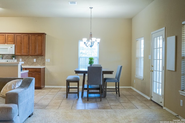 tiled dining space with a chandelier