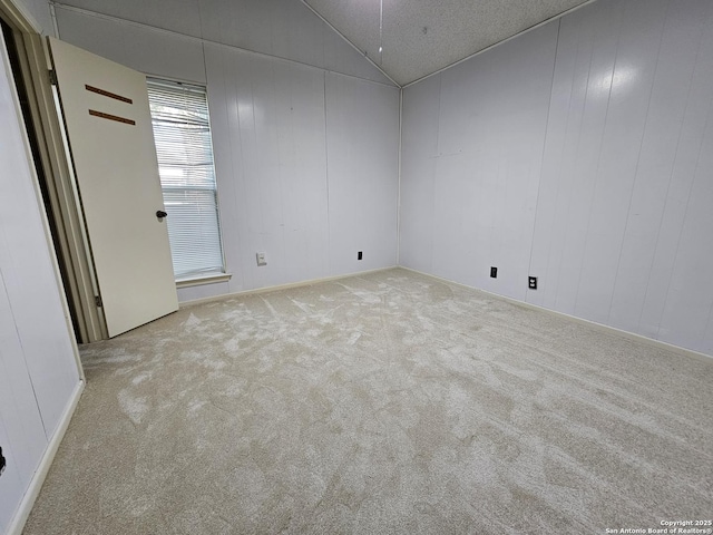 empty room with light colored carpet and lofted ceiling