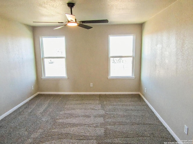 carpeted spare room with ceiling fan, plenty of natural light, and a textured ceiling