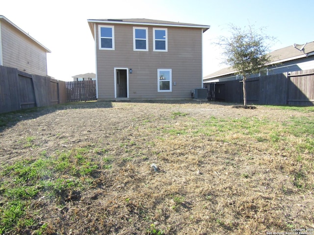 back of property featuring a yard and central air condition unit