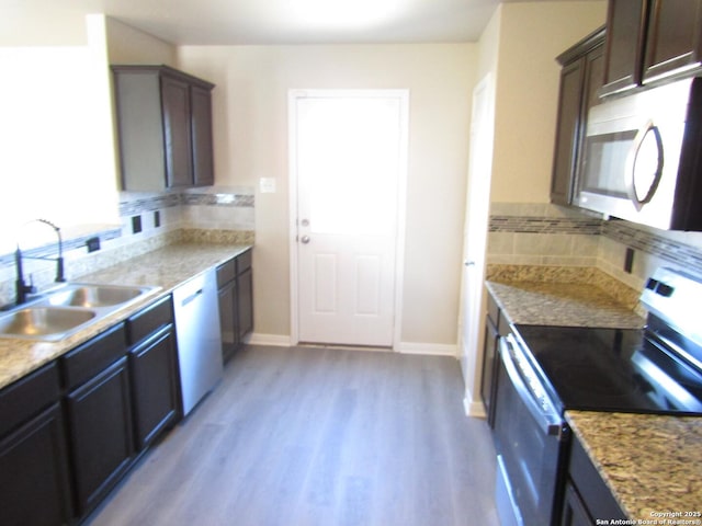 kitchen featuring appliances with stainless steel finishes, sink, dark brown cabinets, and light hardwood / wood-style flooring