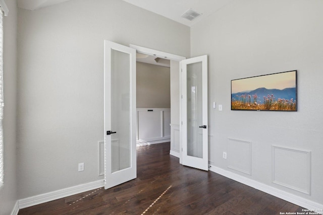 unfurnished room featuring dark hardwood / wood-style flooring and french doors