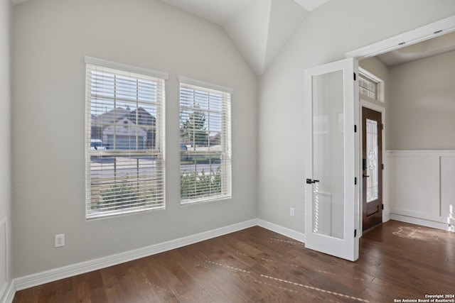 unfurnished room featuring lofted ceiling and dark hardwood / wood-style floors