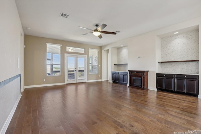 unfurnished living room featuring dark wood-type flooring, french doors, and ceiling fan