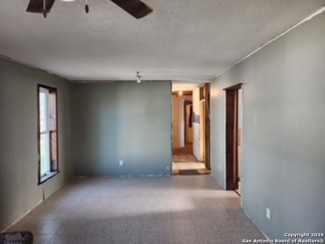 empty room featuring ceiling fan and a textured ceiling