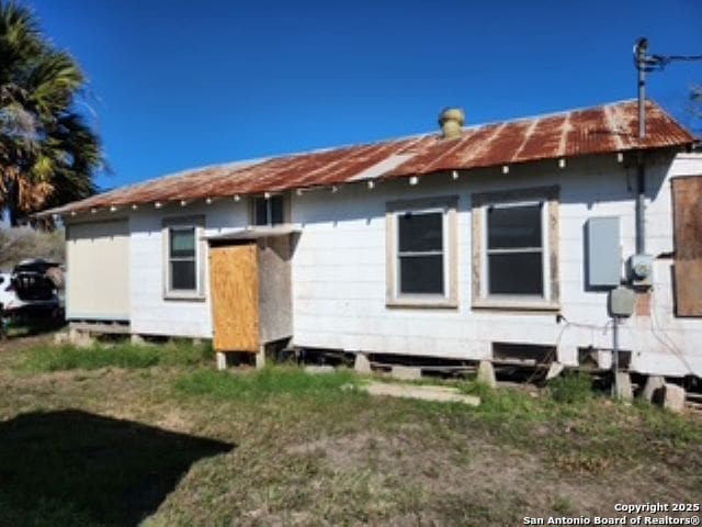 rear view of property featuring a yard