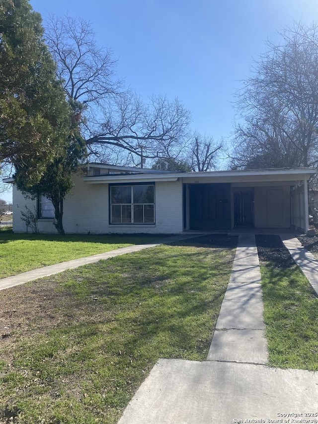 single story home featuring a front lawn and a carport