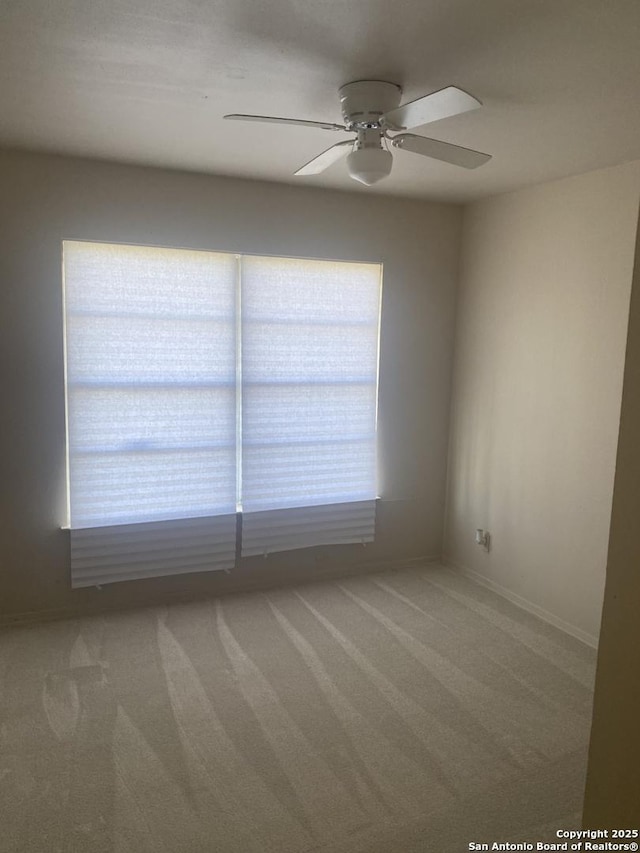 carpeted spare room with ceiling fan