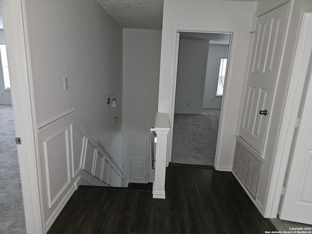 hall with dark hardwood / wood-style floors and a textured ceiling