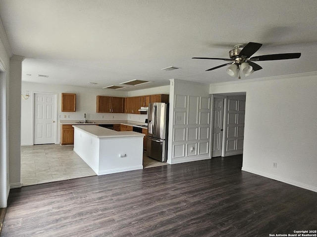 kitchen with sink, range, stainless steel fridge, a kitchen island, and hardwood / wood-style flooring