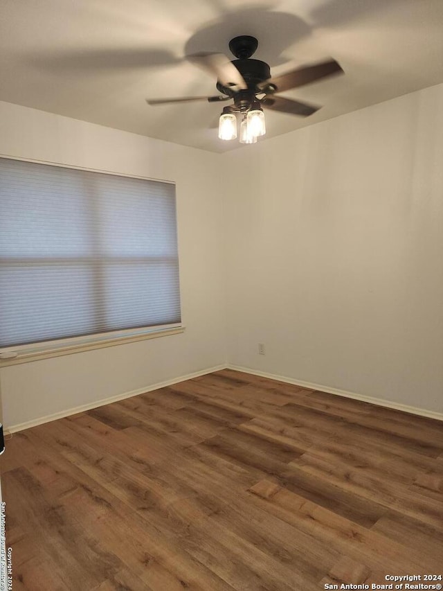 empty room featuring dark wood-type flooring and ceiling fan