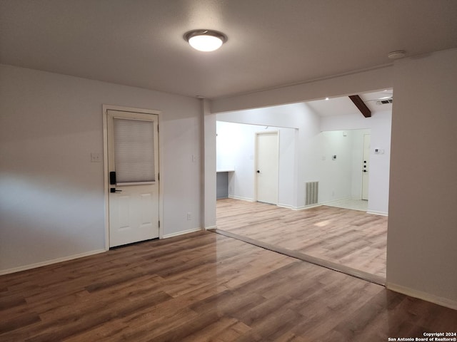 unfurnished room featuring beam ceiling and hardwood / wood-style floors