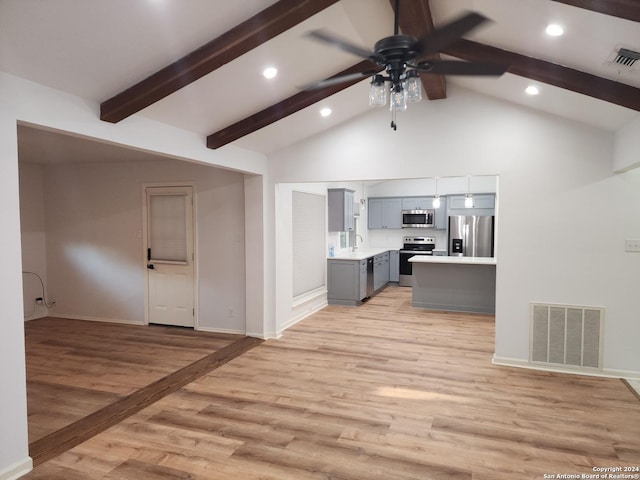 kitchen featuring gray cabinets, beam ceiling, ceiling fan, stainless steel appliances, and light wood-type flooring