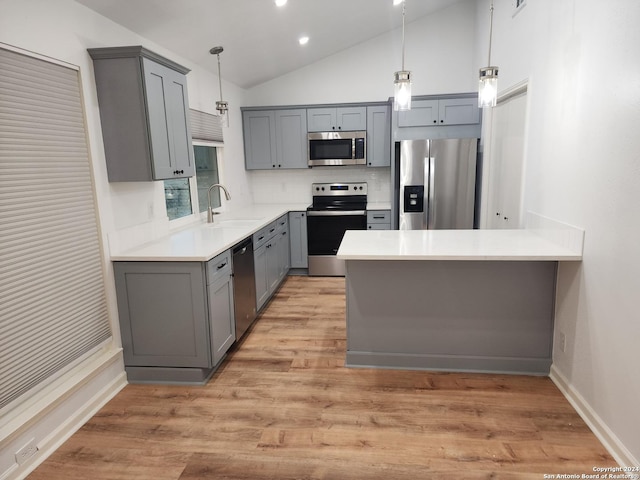 kitchen featuring sink, light hardwood / wood-style flooring, gray cabinets, stainless steel appliances, and decorative light fixtures