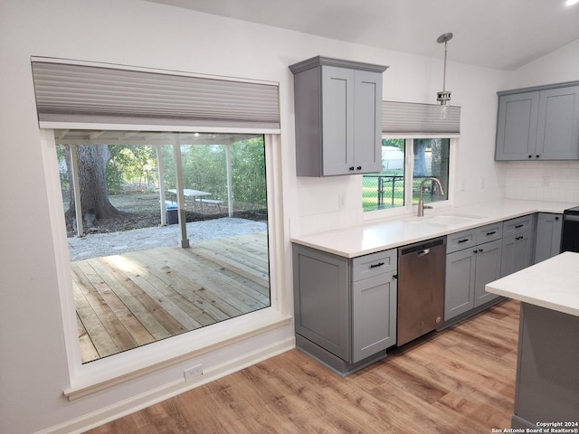 kitchen with sink, light wood-type flooring, stainless steel dishwasher, gray cabinets, and pendant lighting