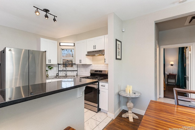 kitchen featuring sink, white cabinetry, appliances with stainless steel finishes, dark stone counters, and backsplash