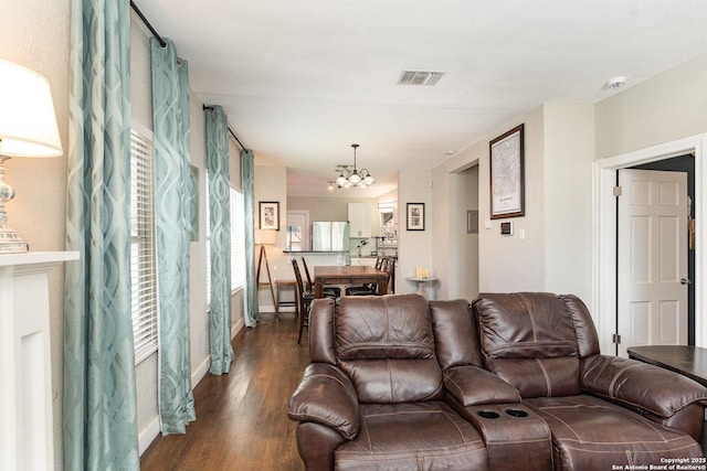 living room featuring dark wood-type flooring and a notable chandelier