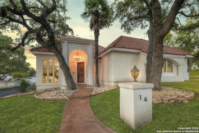 mediterranean / spanish home featuring a yard