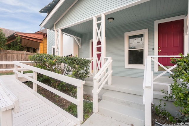 view of exterior entry featuring covered porch