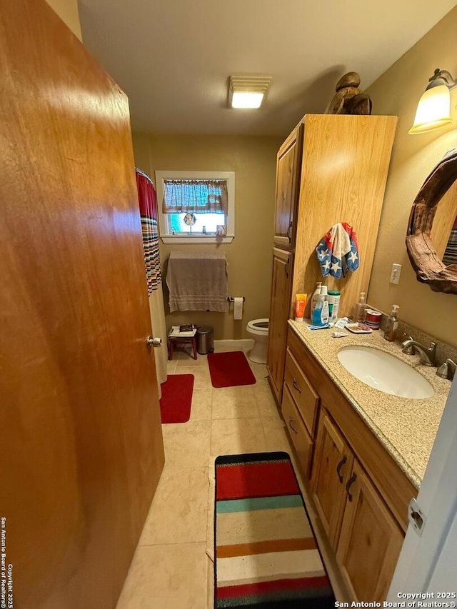 bathroom featuring tile patterned flooring, vanity, and toilet