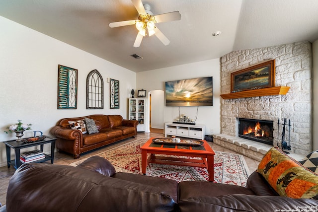 tiled living room featuring ceiling fan and a fireplace