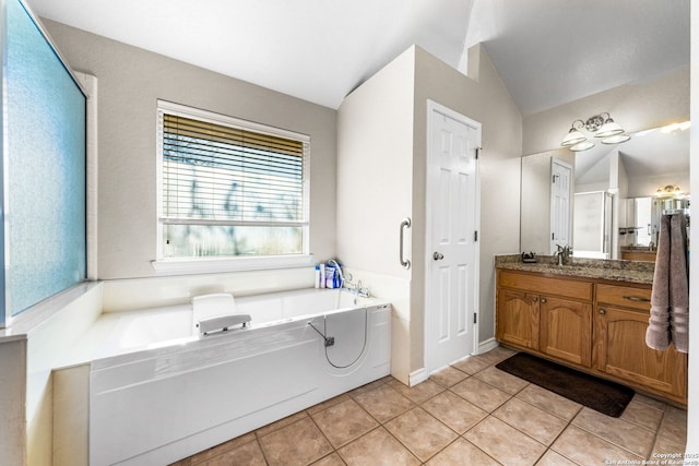 bathroom with vanity, lofted ceiling, a washtub, and tile patterned floors