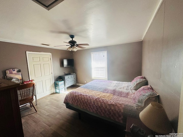 bedroom with crown molding, light hardwood / wood-style flooring, and ceiling fan