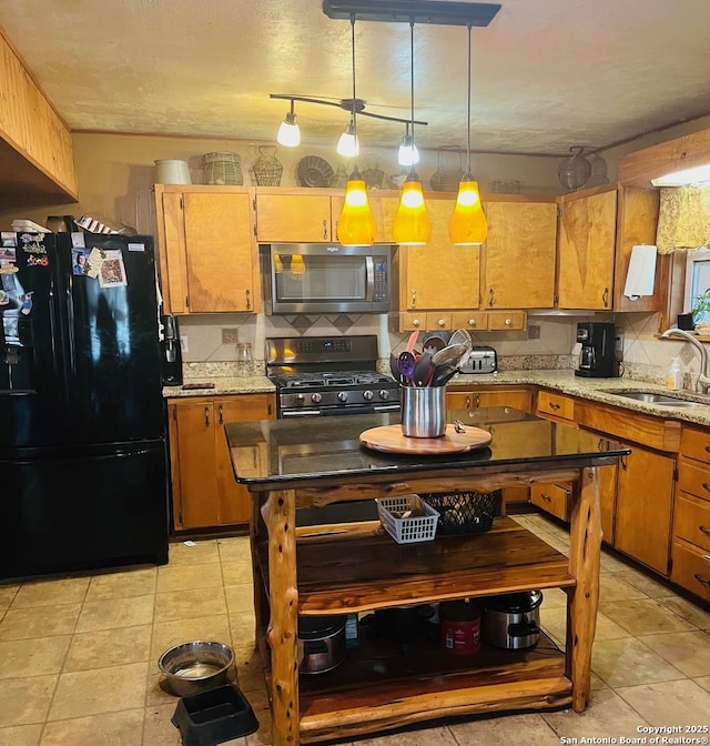 kitchen with sink, tasteful backsplash, decorative light fixtures, light tile patterned floors, and black appliances