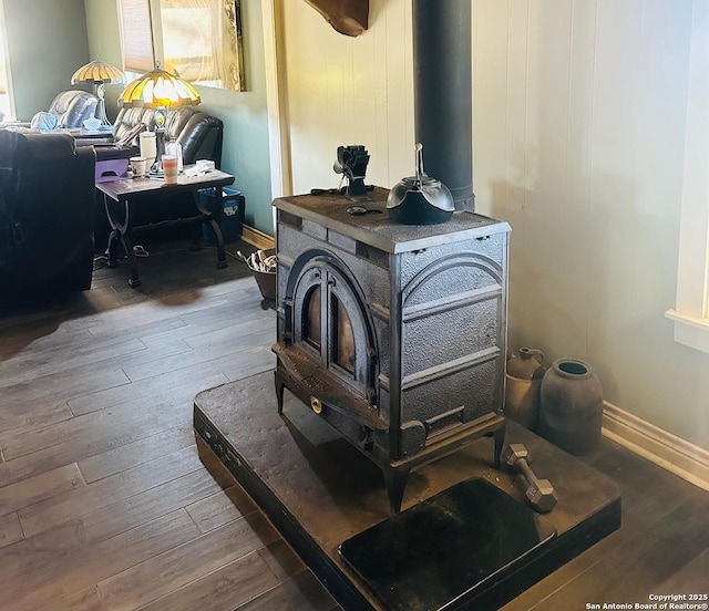 room details with hardwood / wood-style flooring and a wood stove