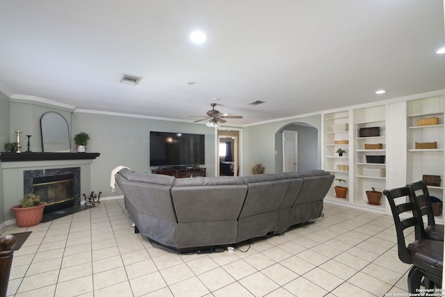 living room featuring a fireplace, ornamental molding, and light tile patterned flooring