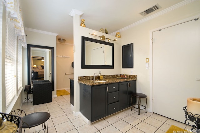 bathroom with crown molding, vanity, and tile patterned flooring