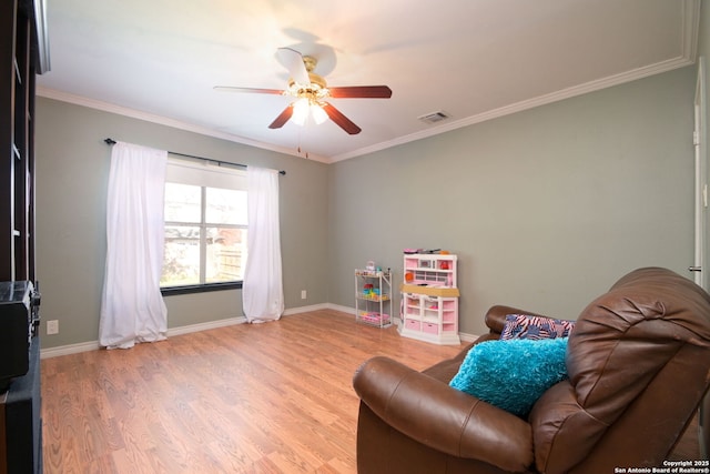 recreation room with wood-type flooring, ceiling fan, and crown molding