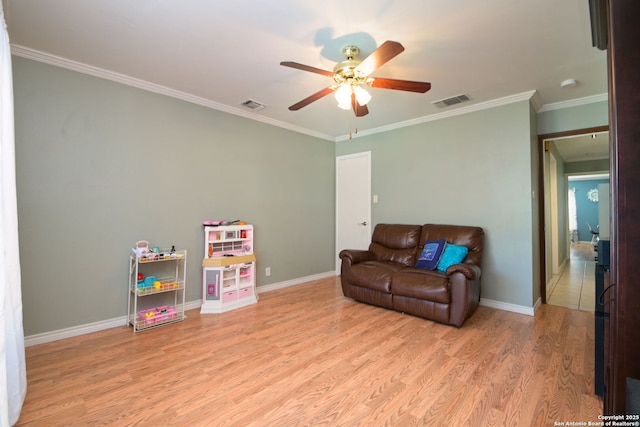 recreation room with crown molding, ceiling fan, and light wood-type flooring