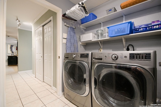 washroom with washing machine and dryer, light tile patterned floors, and crown molding