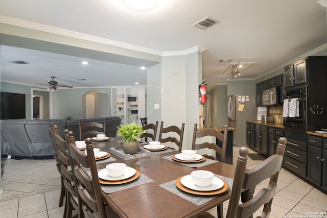 tiled dining space featuring crown molding and ceiling fan