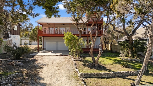 view of front facade with ceiling fan, a garage, a balcony, and a front lawn