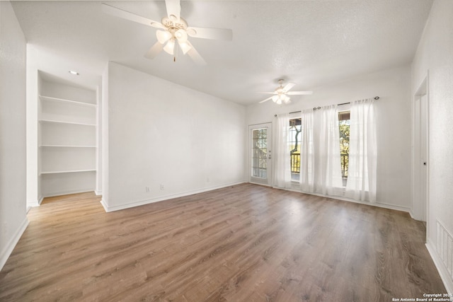 unfurnished room with hardwood / wood-style floors, a textured ceiling, and ceiling fan