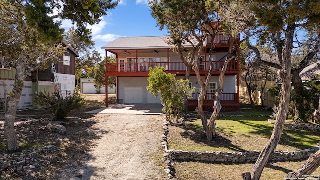 view of front of property featuring ceiling fan, a balcony, and a garage