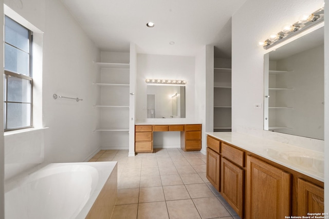 bathroom featuring a tub to relax in, tile patterned floors, and vanity