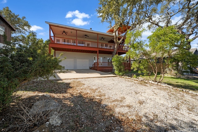 back of property with ceiling fan, a garage, and a balcony