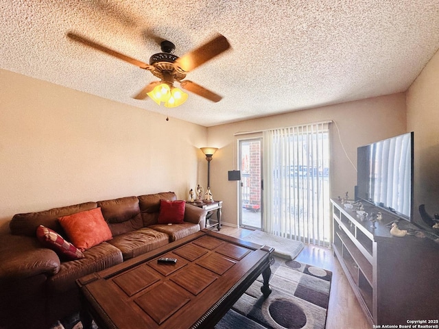 living room with wood-type flooring, a textured ceiling, and ceiling fan