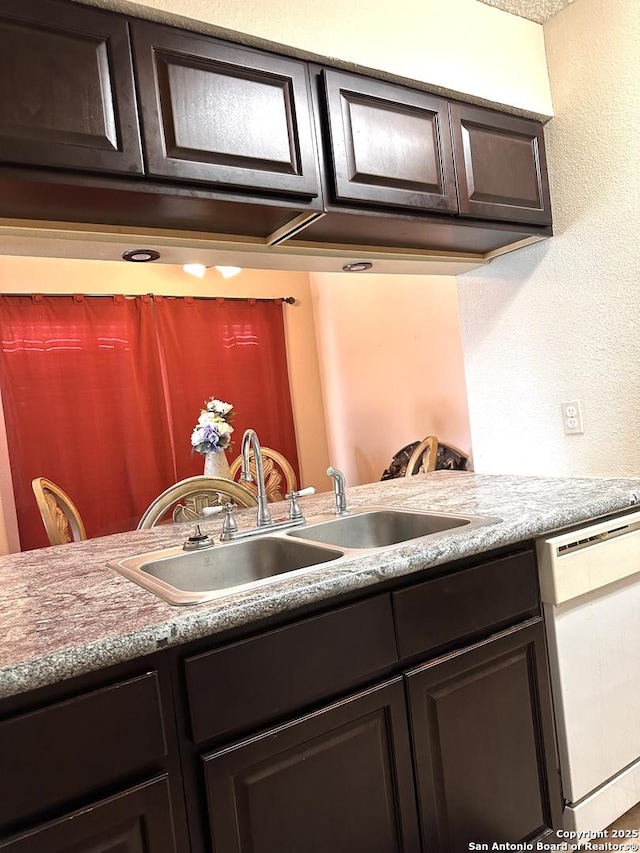 kitchen with dishwasher, sink, and dark brown cabinets