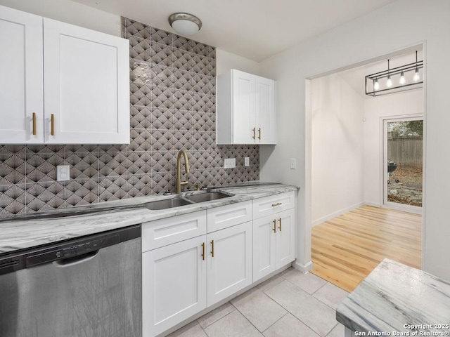 kitchen featuring sink, dishwasher, light stone countertops, white cabinets, and decorative backsplash