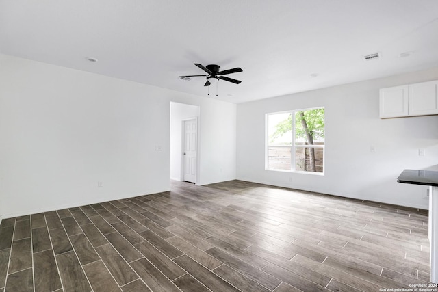 unfurnished living room featuring dark hardwood / wood-style floors and ceiling fan