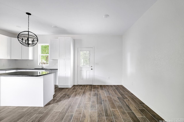 kitchen with a chandelier, sink, hanging light fixtures, and white cabinets