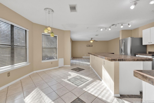 kitchen featuring decorative light fixtures, white cabinetry, stainless steel fridge, light tile patterned floors, and ceiling fan