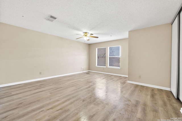 unfurnished room featuring a textured ceiling, light hardwood / wood-style flooring, and ceiling fan