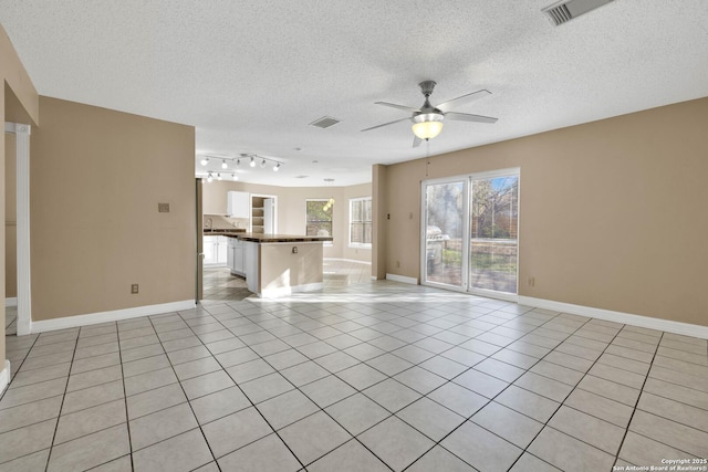 unfurnished living room featuring ceiling fan, a textured ceiling, and light tile patterned floors